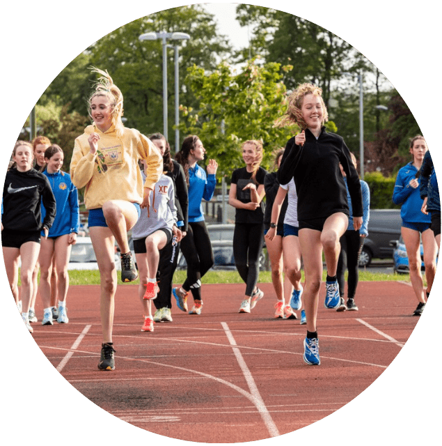 Group of teenagers doing warmup drills on the track